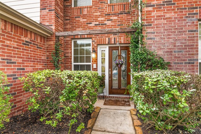 doorway to property featuring brick siding