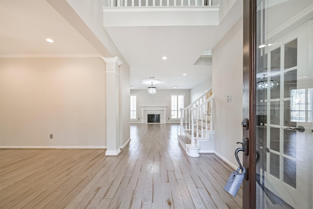 3430 Williams Glen Dr, Sugar Land, TX 77479 - foyer featuring baseboards, wood finished floors, a chandelier, a fireplace, and ornate columns