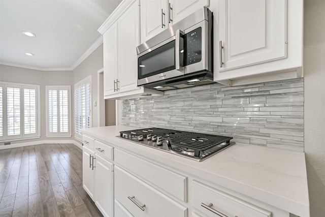 3430 Williams Glen Dr, Sugar Land, TX 77479 - kitchen featuring stainless steel appliances, ornamental molding, decorative backsplash, white cabinetry, and recessed lighting