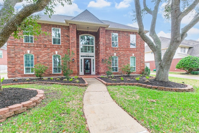 3430 Williams Glen Dr, Sugar Land, TX 77479 - colonial house with brick siding, a front lawn, and a shingled roof