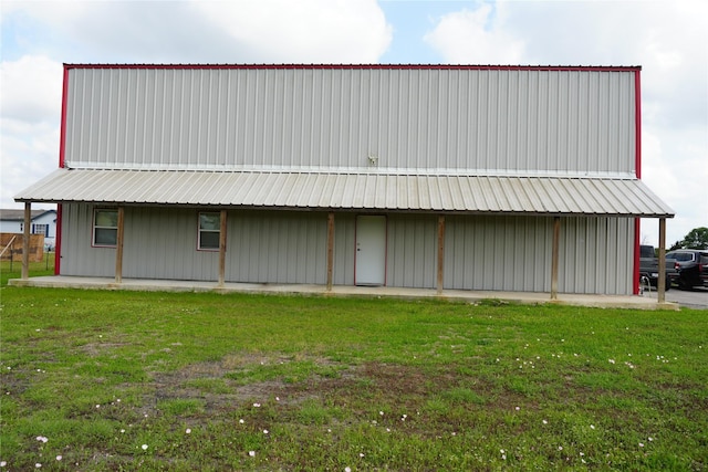 back of house with a yard, board and batten siding, and metal roof