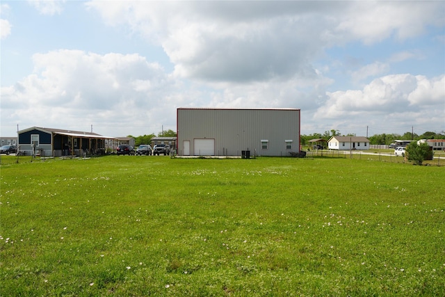 rear view of property with fence, a garage, an outbuilding, a lawn, and an outdoor structure