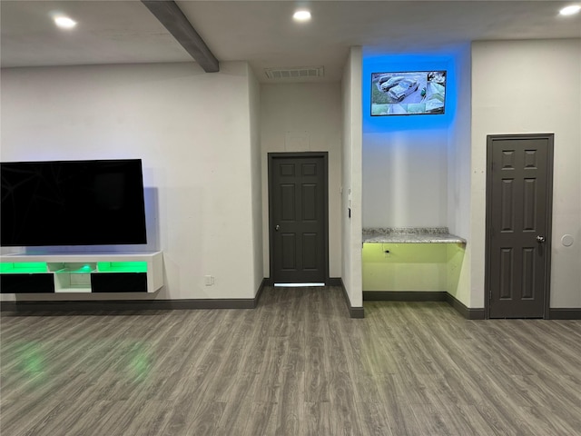 interior space featuring baseboards, recessed lighting, wood finished floors, and visible vents