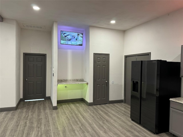 kitchen with gray cabinets, visible vents, black refrigerator with ice dispenser, recessed lighting, and light wood-style flooring