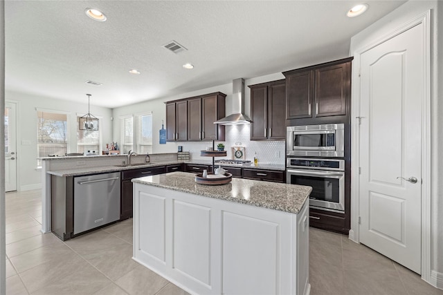 3419 Marlene Meadow Way, Richmond, TX 77406 - kitchen featuring appliances with stainless steel finishes, a sink, wall chimney range hood, a peninsula, and dark brown cabinets