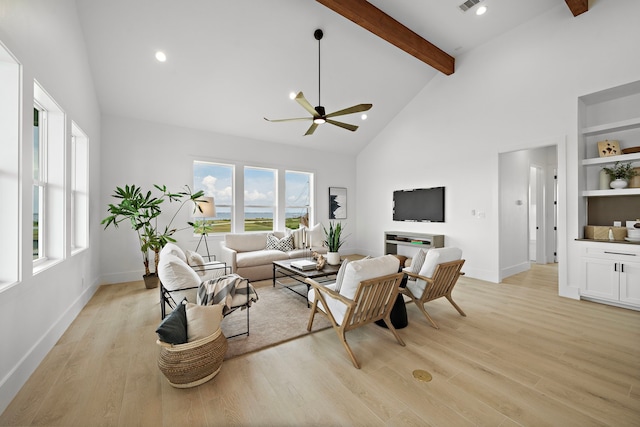 living room with beamed ceiling, ceiling fan, light wood-style flooring, and baseboards