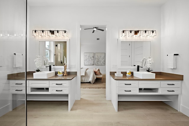 bathroom with two vanities, a sink, a ceiling fan, and ensuite bath