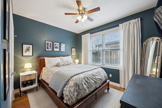 bedroom featuring baseboards, ceiling fan, and wood finished floors