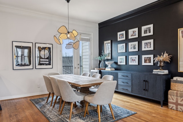dining area with crown molding, light wood finished floors, and baseboards