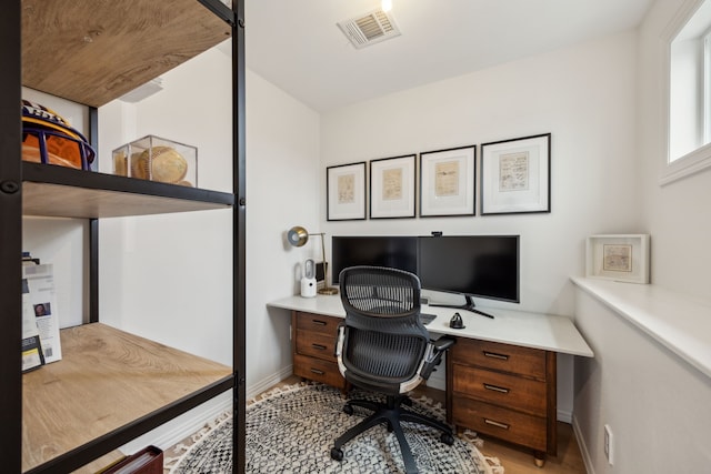 home office featuring baseboards, visible vents, and wood finished floors