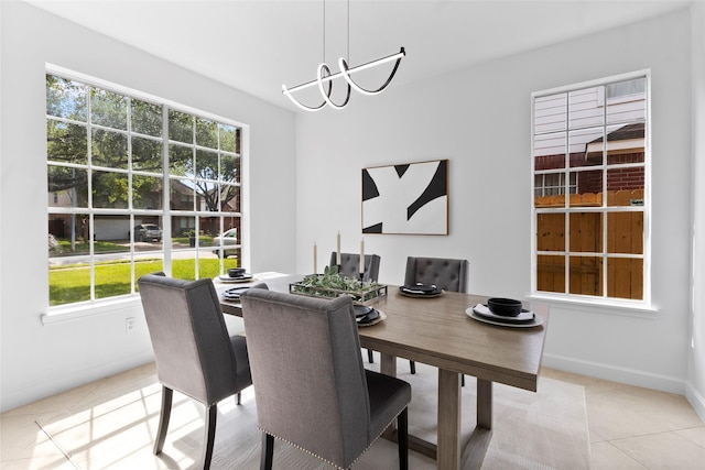 dining room with baseboards, a notable chandelier, a wealth of natural light, and tile patterned flooring