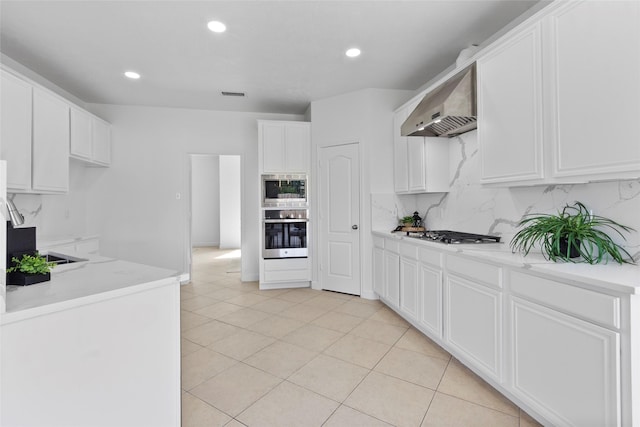 kitchen featuring recessed lighting, stainless steel appliances, backsplash, visible vents, and wall chimney exhaust hood