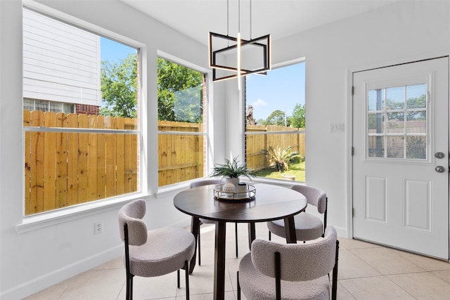 dining room with a chandelier, light tile patterned floors, and a healthy amount of sunlight