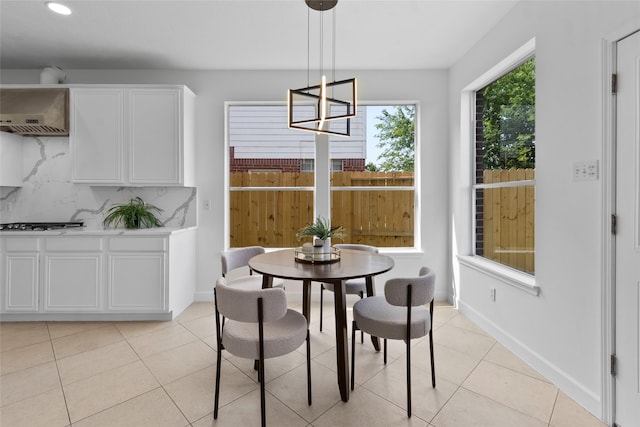 dining room featuring light tile patterned floors, a notable chandelier, and baseboards