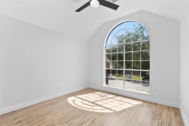spare room with baseboards, wood finished floors, a ceiling fan, and vaulted ceiling