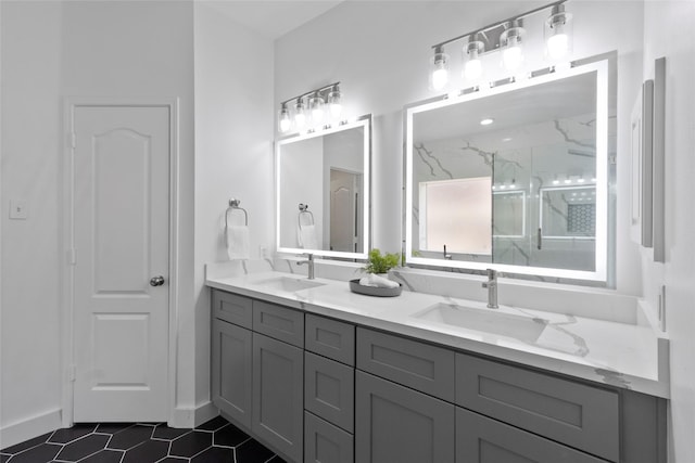 bathroom with double vanity, a marble finish shower, tile patterned flooring, and a sink