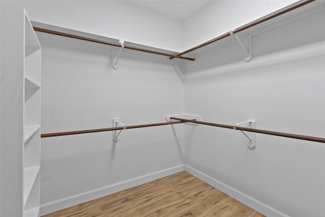 walk in closet with wood finished floors