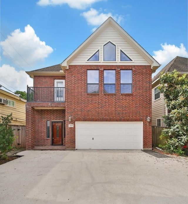 traditional home with a balcony, brick siding, concrete driveway, an attached garage, and fence