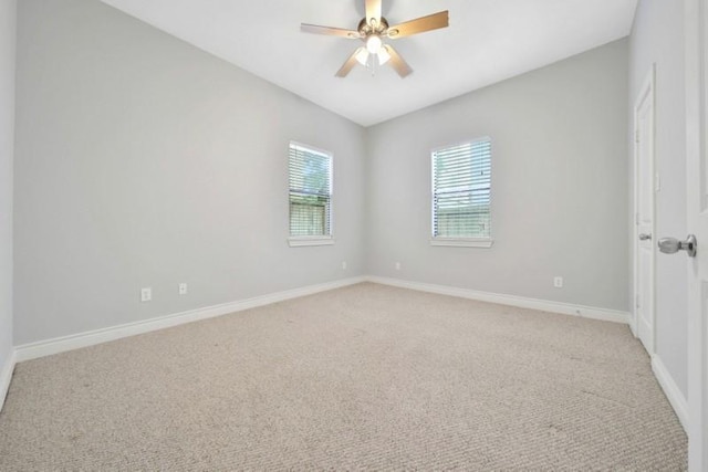 empty room with a ceiling fan, light carpet, and baseboards