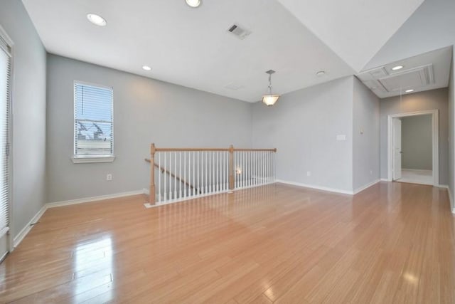 empty room featuring baseboards, recessed lighting, attic access, and light wood finished floors