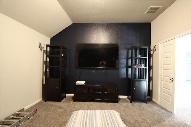 interior space with carpet floors, visible vents, and vaulted ceiling