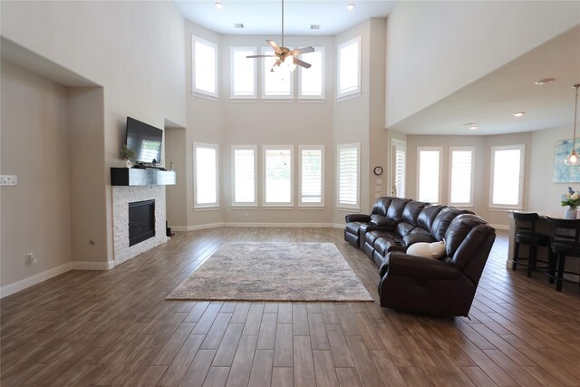 living room featuring a ceiling fan, dark wood-style flooring, and a healthy amount of sunlight