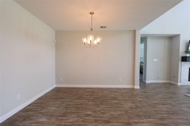 unfurnished room with baseboards, visible vents, dark wood-type flooring, and a chandelier
