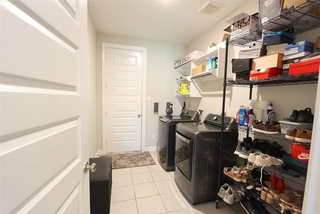 washroom featuring laundry area, light tile patterned floors, separate washer and dryer, and visible vents