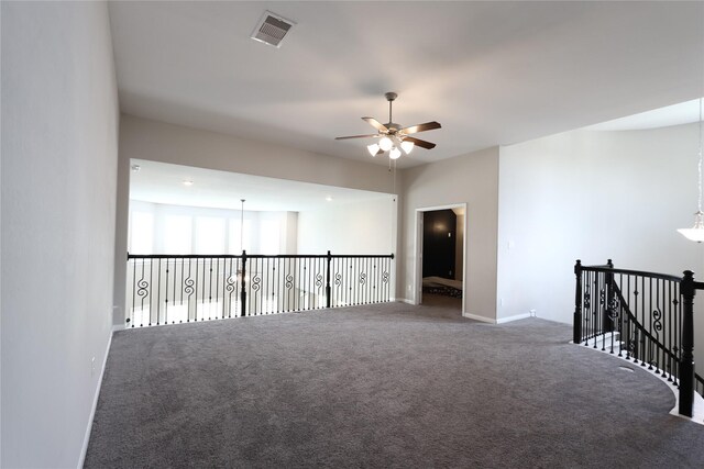unfurnished room featuring carpet floors, ceiling fan, visible vents, and baseboards