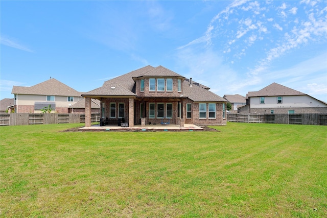 back of house with brick siding, a fenced backyard, a yard, and a patio