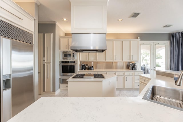 kitchen featuring a sink, built in appliances, crown molding, a kitchen island, and island range hood