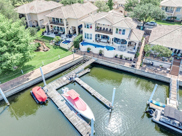view of dock featuring a patio area, a balcony, a water view, and a fenced backyard