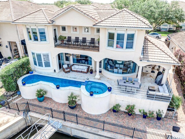 rear view of property with an outdoor living space, a balcony, and a tiled roof