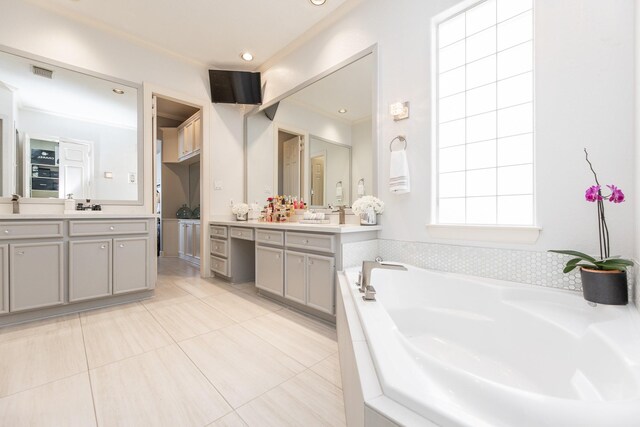 bathroom featuring a garden tub, two vanities, visible vents, and tile patterned floors