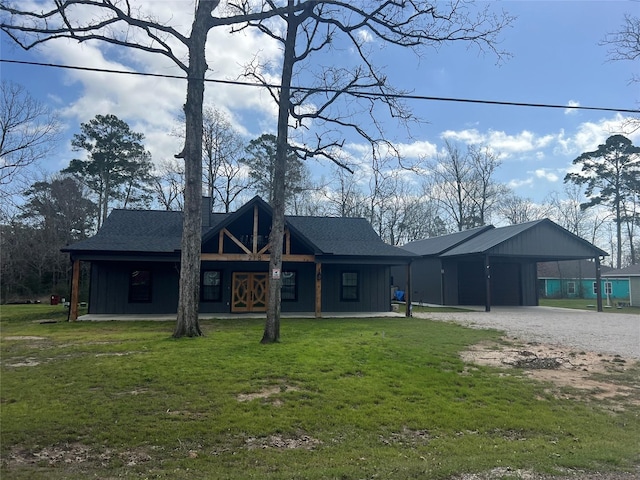 218 Strawberry St, Onalaska, TX 77360 - view of front facade featuring a front lawn, driveway, an attached carport, and board and batten siding
