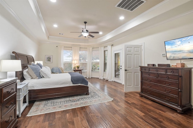 bedroom with recessed lighting, ornamental molding, dark wood-style flooring, visible vents, and a tray ceiling