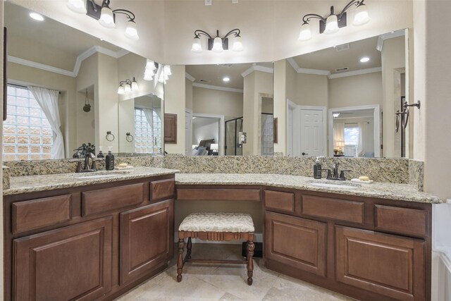 full bathroom with double vanity, crown molding, and a sink