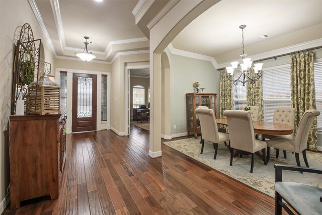 foyer featuring a chandelier, visible vents, baseboards, arched walkways, and dark wood finished floors
