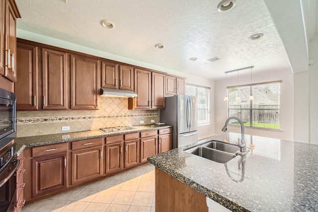 27122 Sable Oaks Ln, Cypress, TX 77433 - kitchen featuring decorative backsplash, visible vents, stainless steel appliances, a sink, and under cabinet range hood
