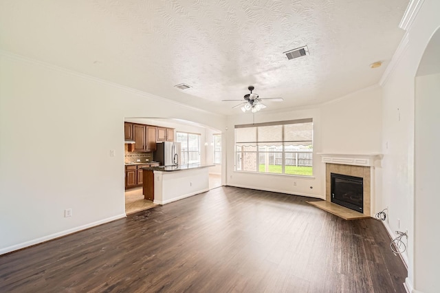27122 Sable Oaks Ln, Cypress, TX 77433 - unfurnished living room featuring visible vents, dark wood-type flooring, ceiling fan, and arched walkways