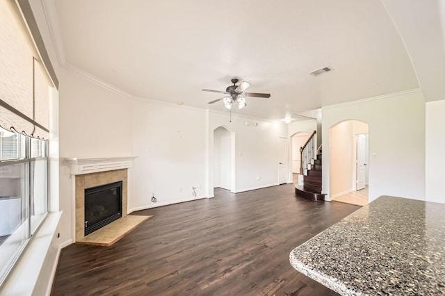 27122 Sable Oaks Ln, Cypress, TX 77433 - unfurnished living room with crown molding, arched walkways, ceiling fan, and a tiled fireplace