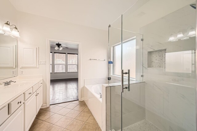 full bathroom with a garden tub, tile patterned flooring, vanity, a ceiling fan, and a stall shower