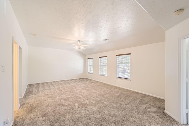 carpeted empty room with a ceiling fan, baseboards, and a textured ceiling