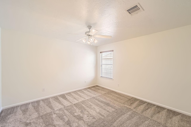 empty room with visible vents, baseboards, light colored carpet, a textured ceiling, and a ceiling fan