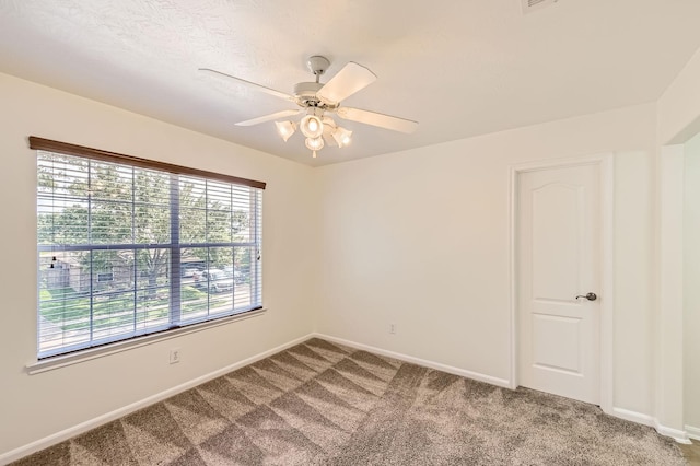 empty room featuring baseboards, ceiling fan, and carpet