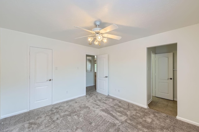 unfurnished bedroom with baseboards, carpet, and a ceiling fan