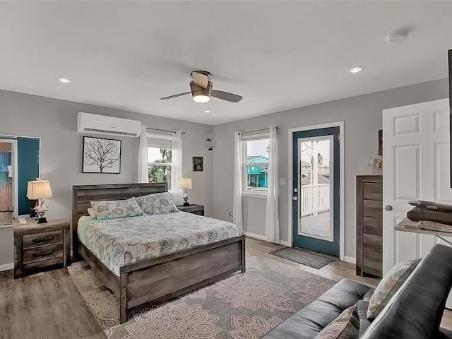 4006 Reeves Dr, Galveston, TX 77554 - bedroom with a wall mounted AC, access to exterior, light wood finished floors, baseboards, and ceiling fan