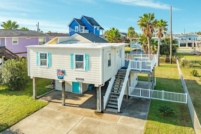 4006 Reeves Dr, Galveston, TX 77554 - rear view of property with a carport, stairway, a residential view, and concrete driveway