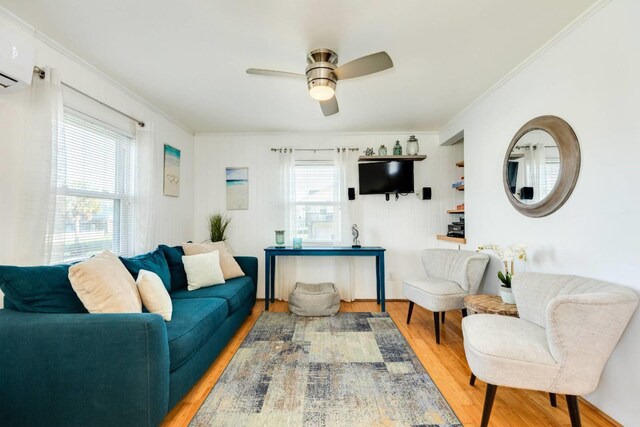 4006 Reeves Dr, Galveston, TX 77554 - living room with ornamental molding, light wood finished floors, a wall unit AC, and a ceiling fan