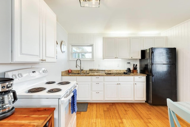 4006 Reeves Dr, Galveston, TX 77554 - kitchen with black appliances, a sink, light stone counters, white cabinetry, and light wood-style flooring